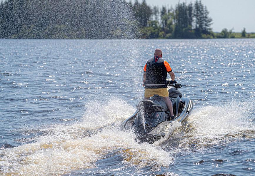 a man riding a jet ski in the water at Lochview Retreat Caravan in Balminnoch