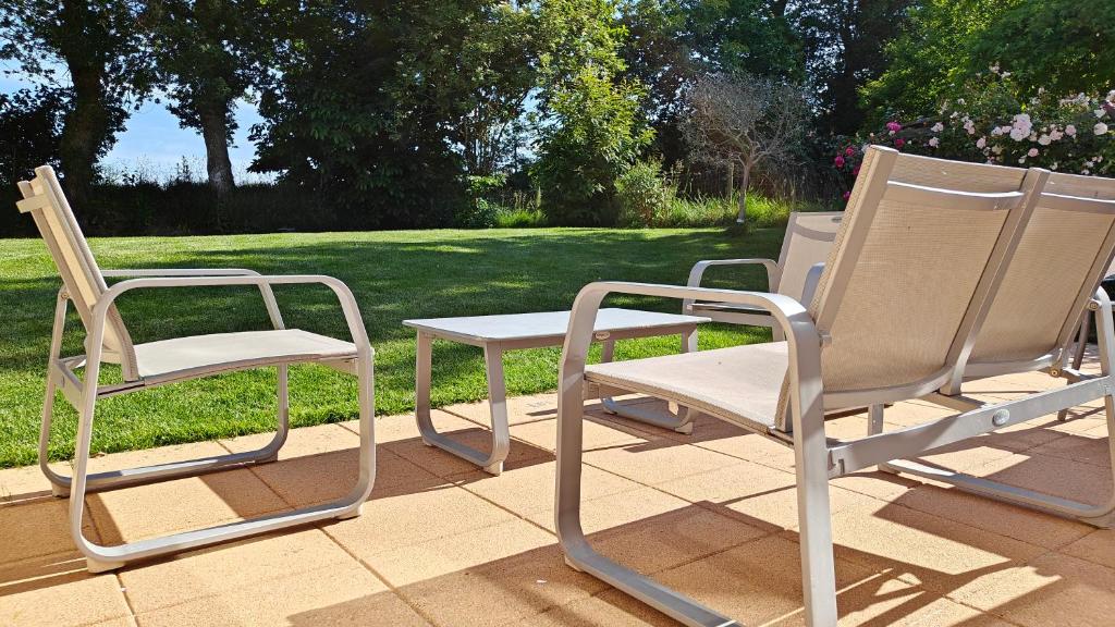 deux chaises et une table sur une terrasse dans l'établissement Maison familiale au cœur du pays de Brocéliande, à Montfort-sur-Meu