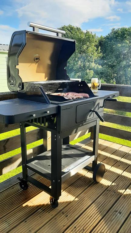 a grill on a table on a deck at Lochview Retreat Caravan in Balminnoch