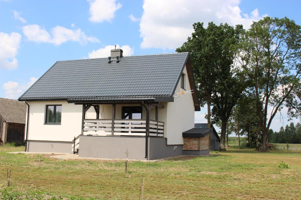 a small white house with a gambrel roof at Ostoja Tatary Agroturystyka in Tykocin