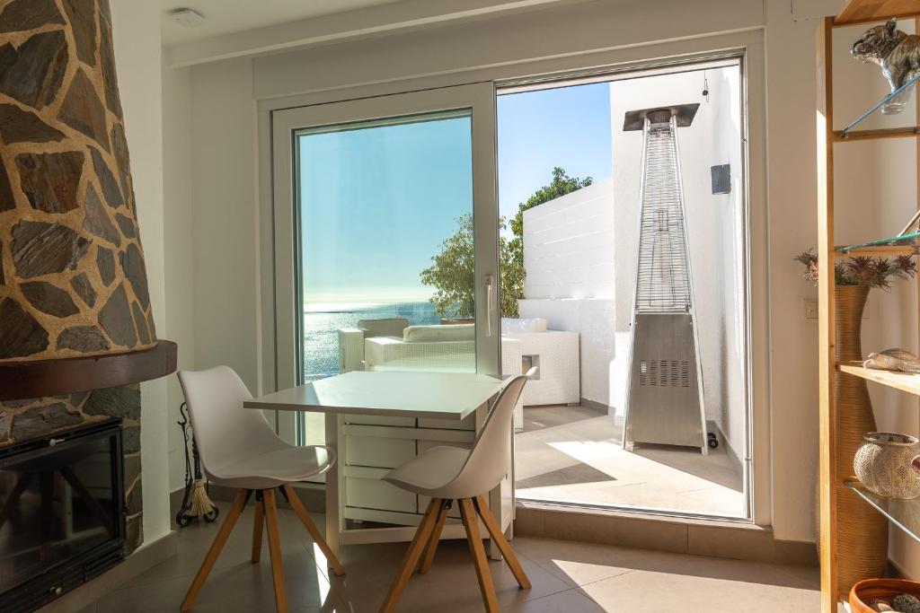 a room with a table and chairs and a fireplace at Maryvilla Inspiración y Vacaciones - Bungalows in Calpe