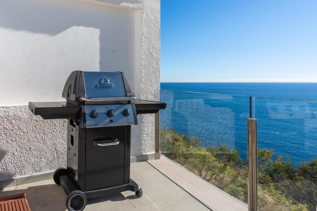 a grill on a balcony with a view of the ocean at Maryvilla Inspiración y Vacaciones - Bungalows in Calpe