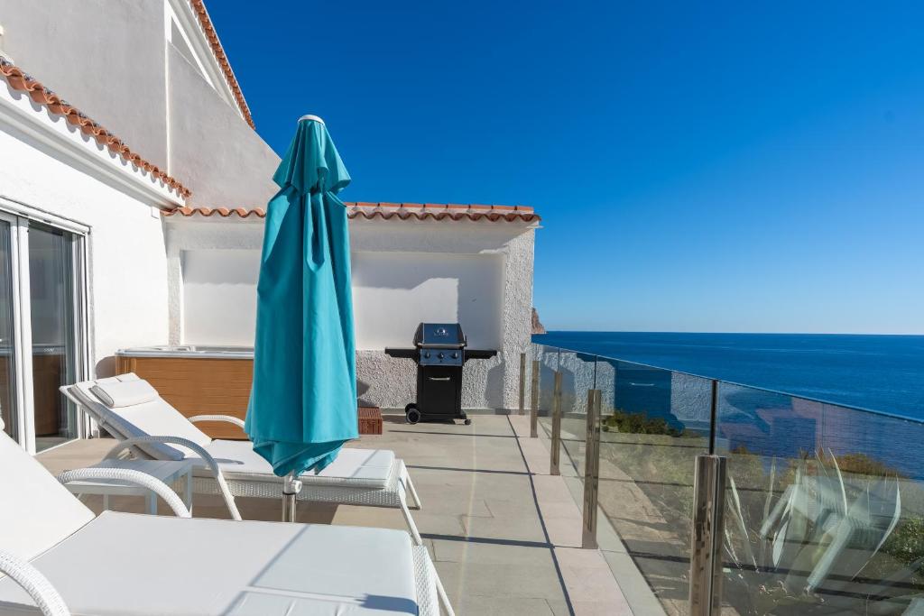 a patio with a table and a blue umbrella at Maryvilla Inspiración y Vacaciones - Bungalows in Calpe