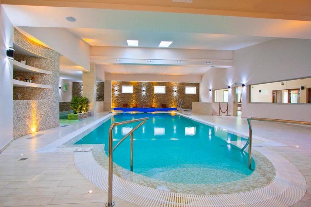 a large swimming pool in a hotel lobby at Hotel Orizont in Călimăneşti