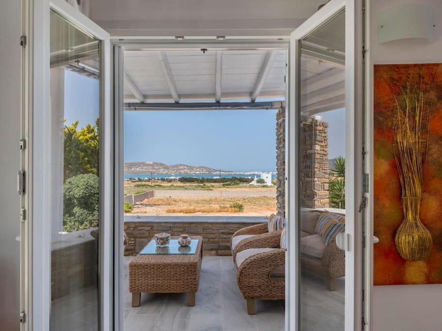 een woonkamer met een bank en een glazen deur bij Angel Serenity Villa in Kampos Paros