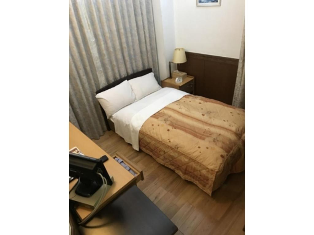 東京にあるBusiness Hotel Crescent - Vacation STAY 49310vのベッドとテーブルのあるホテルの部屋