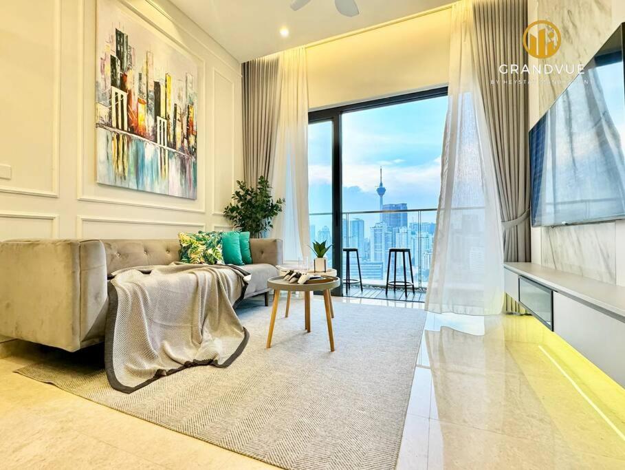 a living room with a couch and a large window at Lucentia BukitBintang KlccView InfinityPool By HeyStay Management in Kuala Lumpur