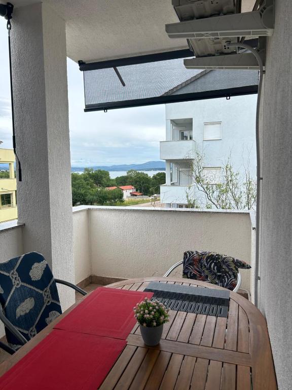 a balcony with a table and a view of a building at Apartments Marina in Posedarje