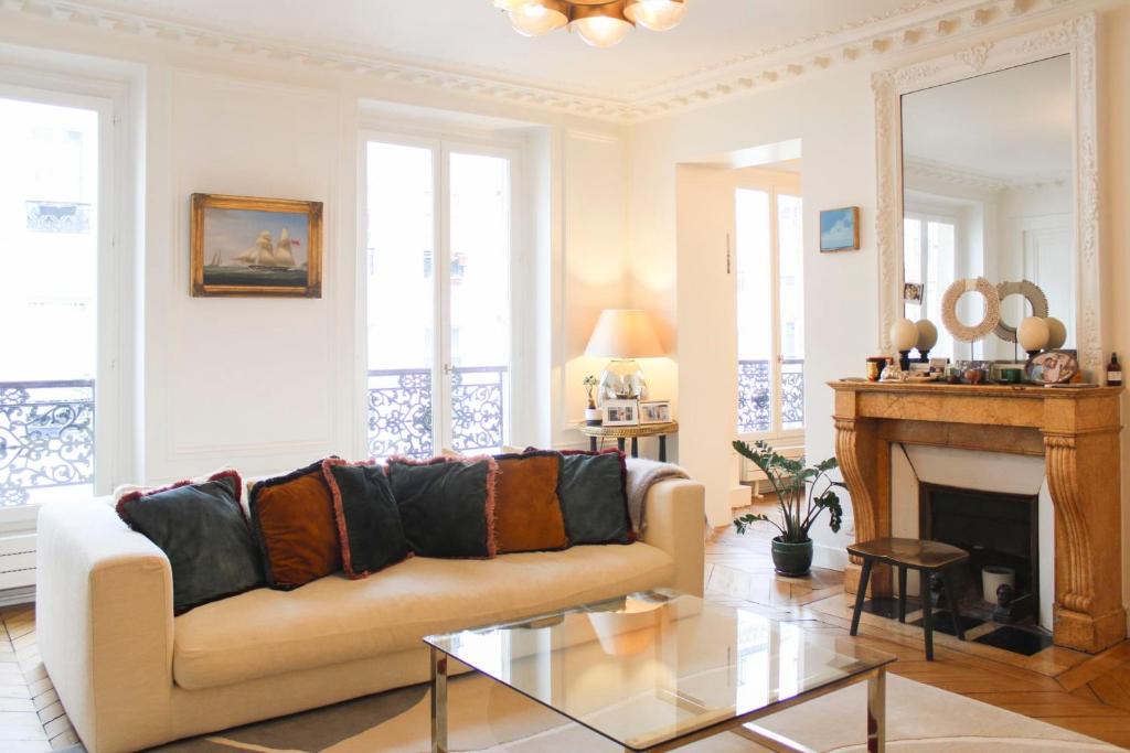 un salon avec un canapé et une cheminée dans l'établissement Cozy Haussmanian flat in the heart of Paris, à Paris