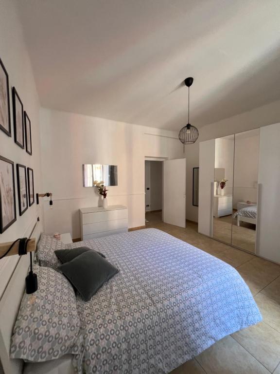 a white bedroom with a large bed and a mirror at La camera a due passi dal mare in San Terenzo