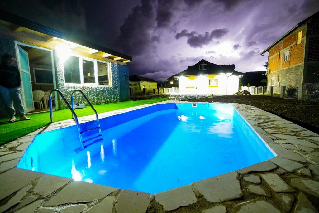 a large blue swimming pool at night at Apartment Lane in Bihać