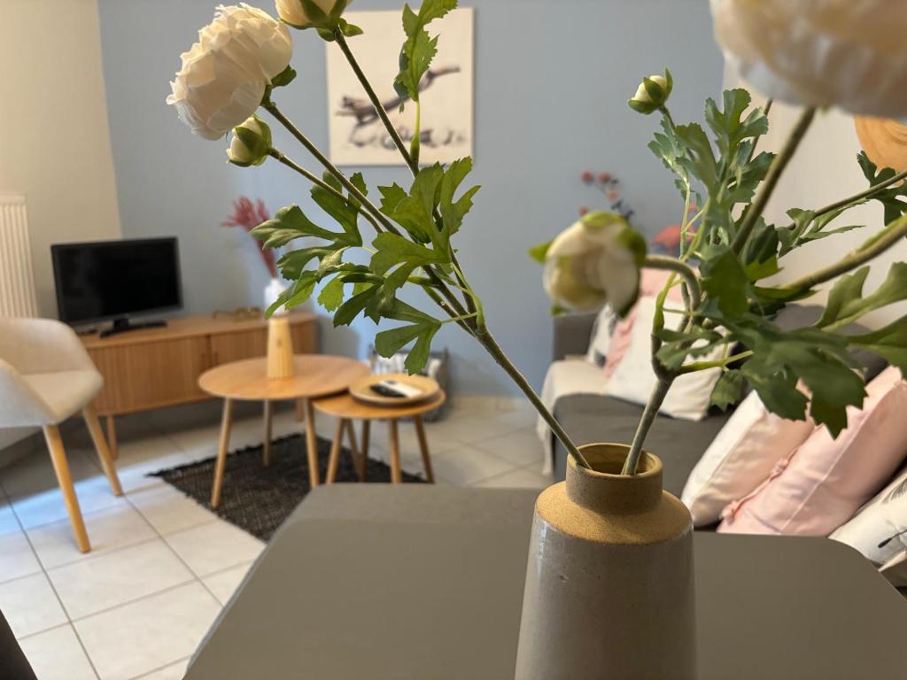 a vase with white flowers on a table in a living room at Blooming 31 AXD in Alexandroupoli