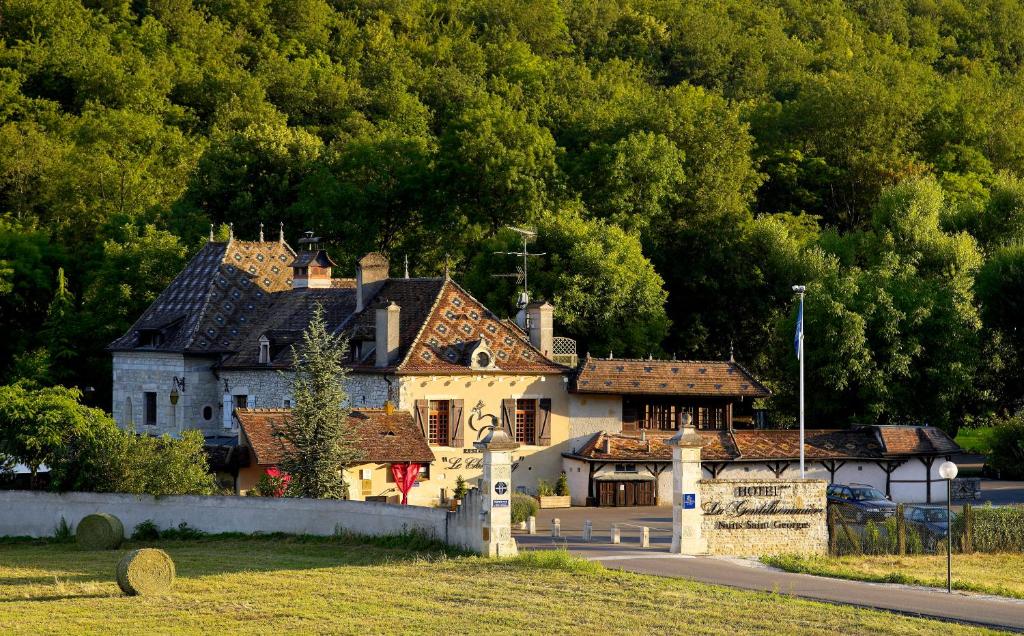 uma casa grande sentada ao lado de uma estrada em Hôtel La Gentilhommière em Nuits-Saint-Georges