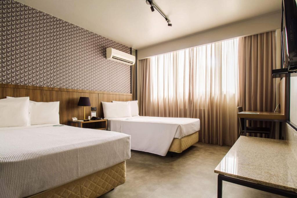 Postel nebo postele na pokoji v ubytování Hotel Deville Business Maringá