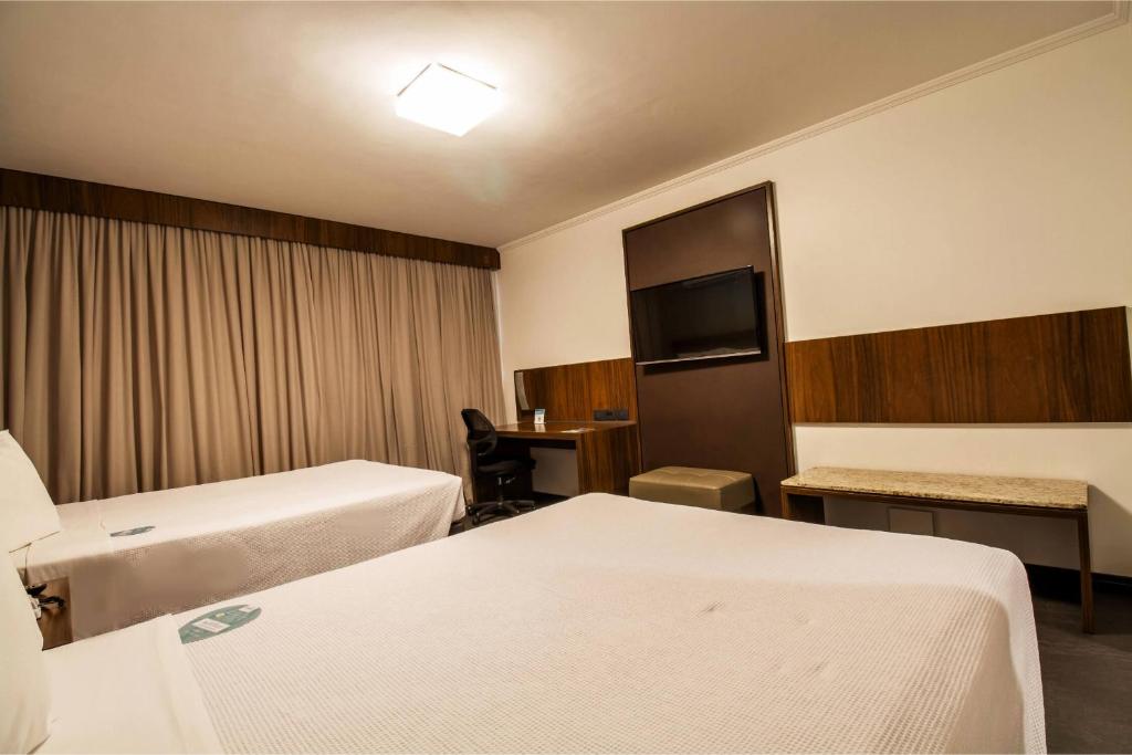 Postel nebo postele na pokoji v ubytování Hotel Deville Business Maringá