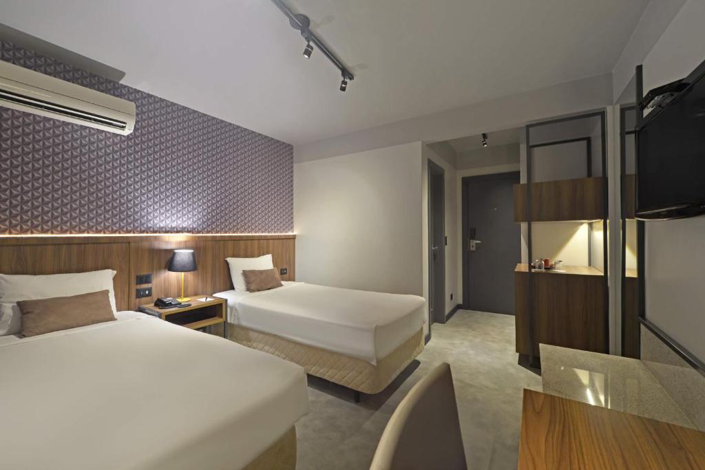 Postel nebo postele na pokoji v ubytování Hotel Deville Business Maringá