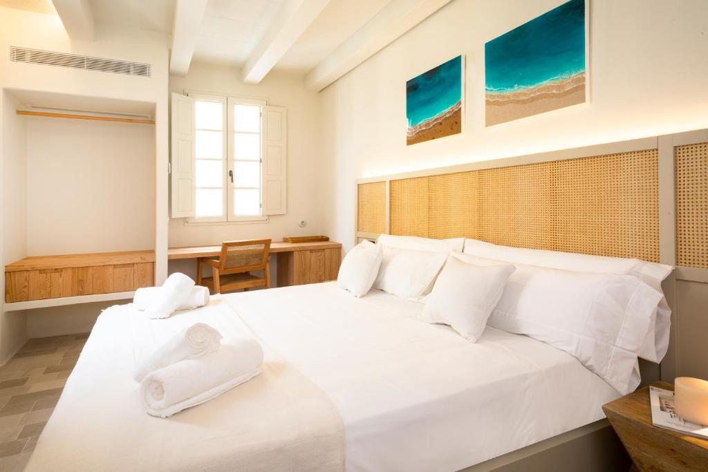 een slaapkamer met een groot wit bed met witte kussens bij SetBlaus Boutique Hotel in Ciutadella