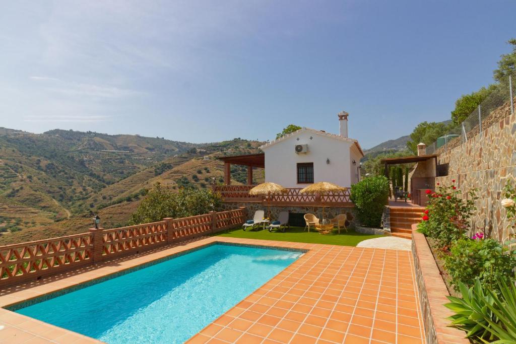 a villa with a swimming pool and a house at Villa Castillo in Frigiliana