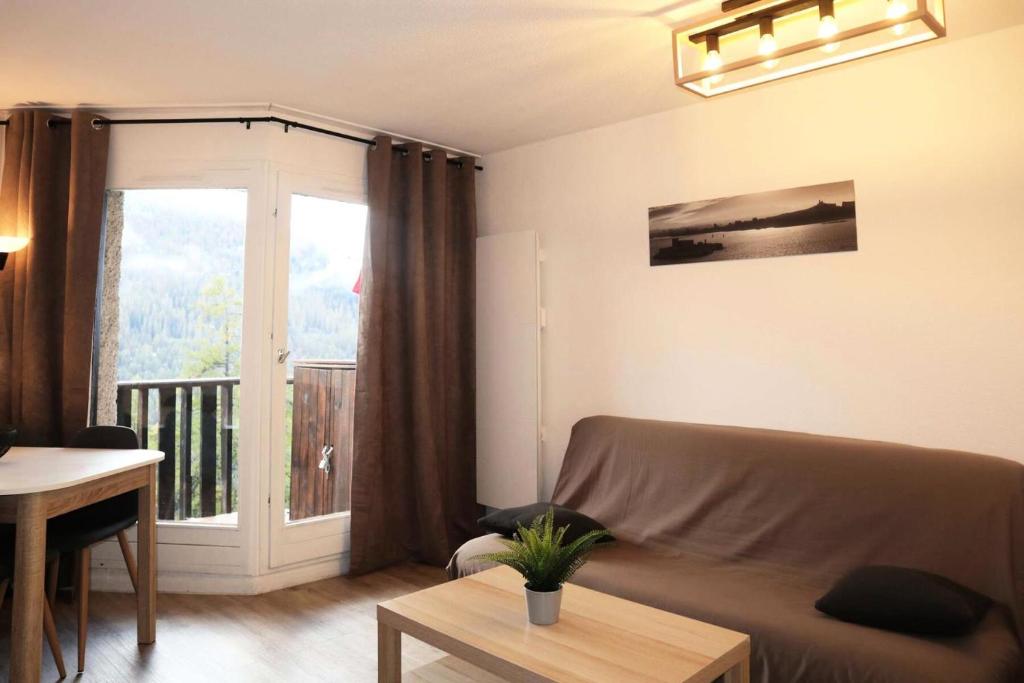 d'un salon avec un canapé et un balcon. dans l'établissement Résidence L'oustal - Joli studio équipé pour 6 personnes MAE-1461, aux Orres
