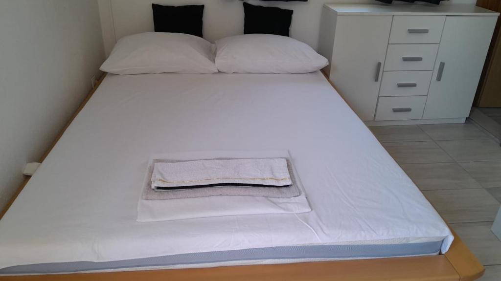a large white bed with a towel on it at Studio Apartment Sanja 3 in Neum