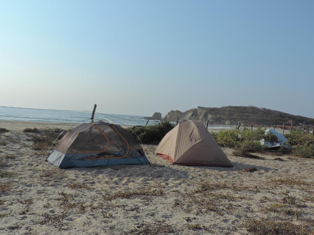 two tents on a sandy beach next to the ocean at Natevo Surf Camping in Barra