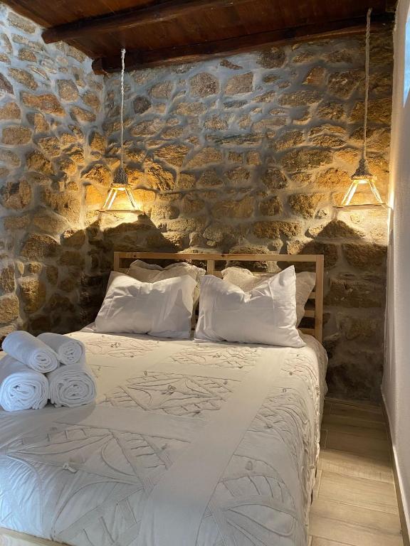 um quarto com uma cama numa parede de pedra em Cantinho D'Avó Maria em Zebreira