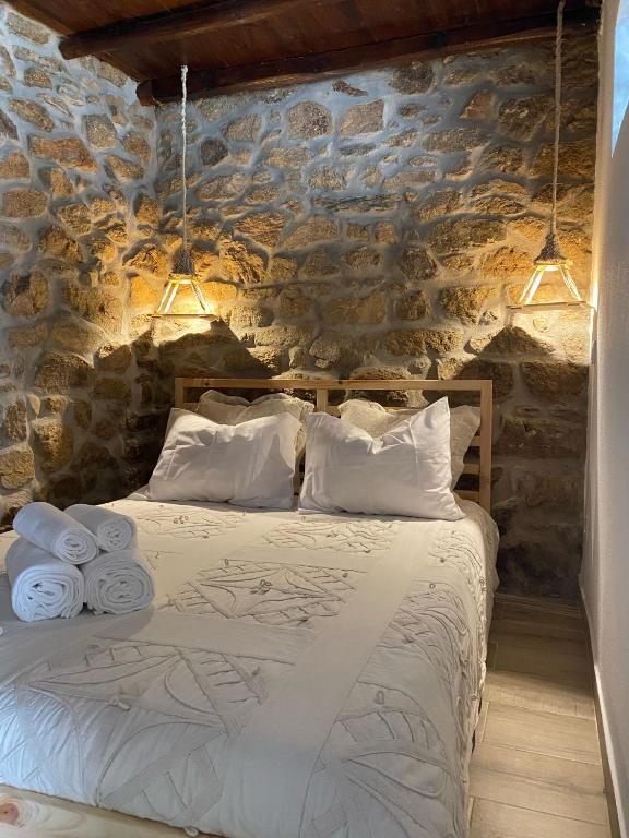 um quarto com uma cama numa parede de pedra em Cantinho D'Avó Maria em Zebreira