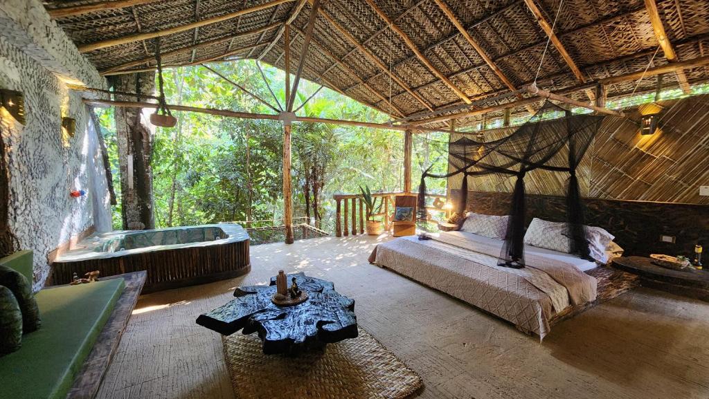 sypialnia z łóżkiem, stołem i wanną w obiekcie EntreAguas Ecolodge w mieście Doradal