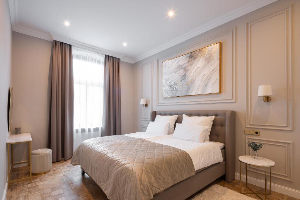 a bedroom with a large bed with white pillows at Aurum Suite - Luxuriöses City Apartment in Würzburg