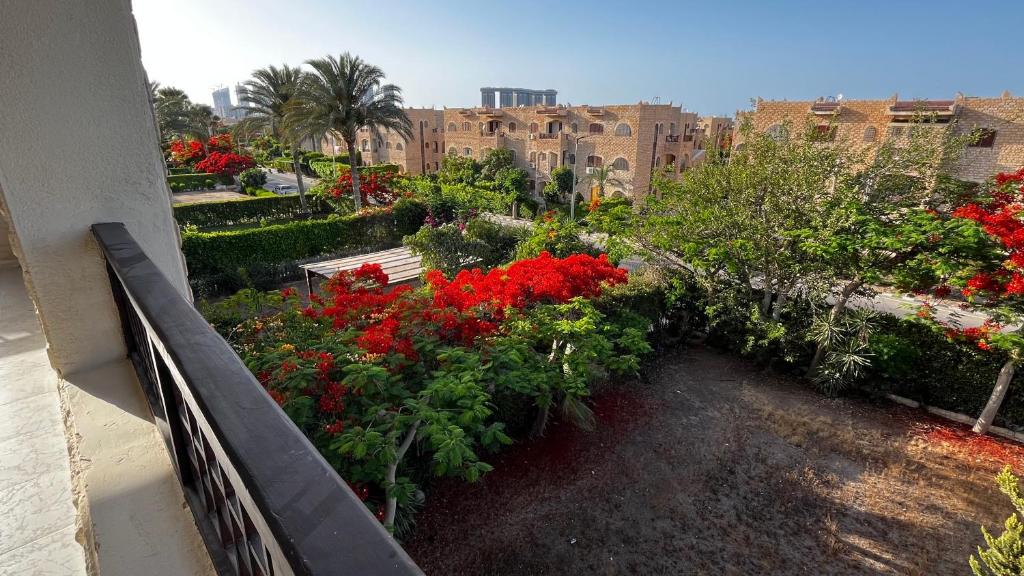 a garden with red flowers and a bench on a balcony at Chalet in Marina 6 District 31 in El Alamein