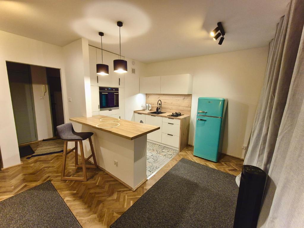 a kitchen with a counter and a blue refrigerator at Klimatyczna kawalerka w centrum No 2 in Gdynia