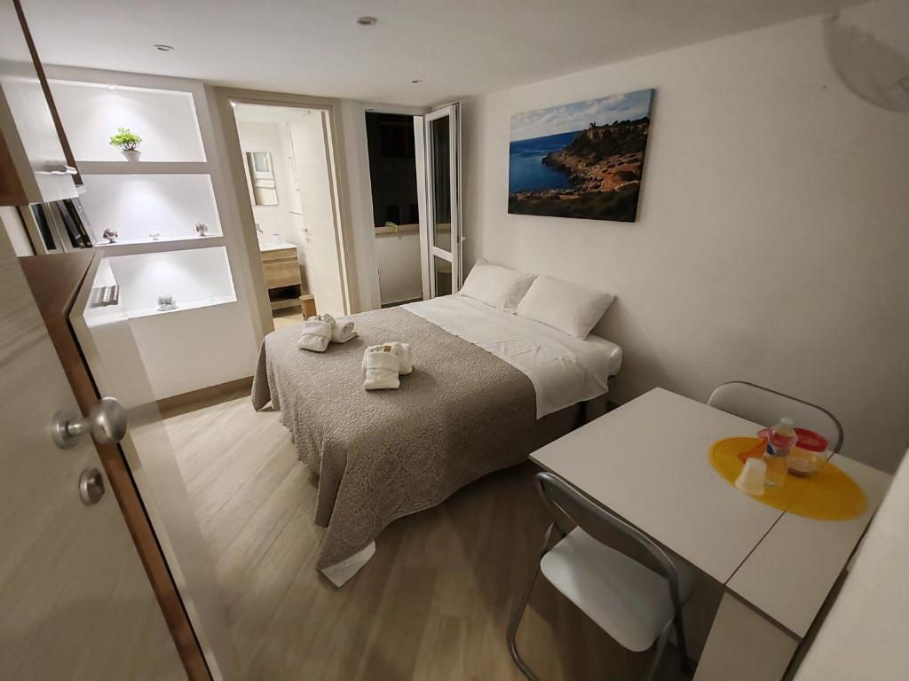 a small bedroom with a bed and a table at Holiday House in Nardò