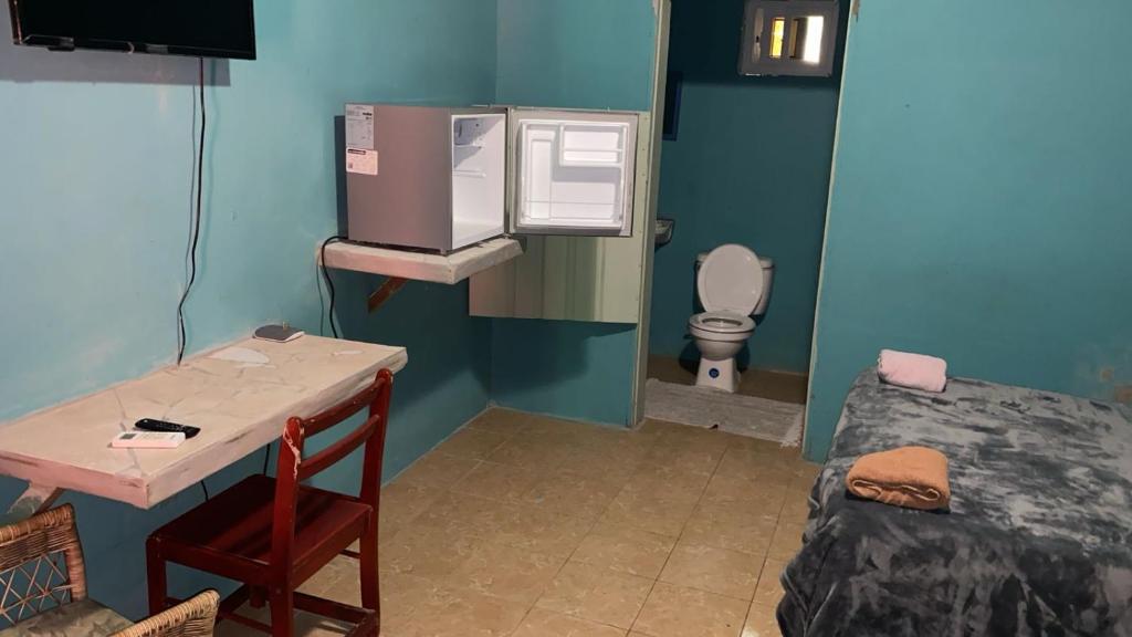a small room with a bed and a small bathroom at Airport Inn Roatan in Coxen Hole
