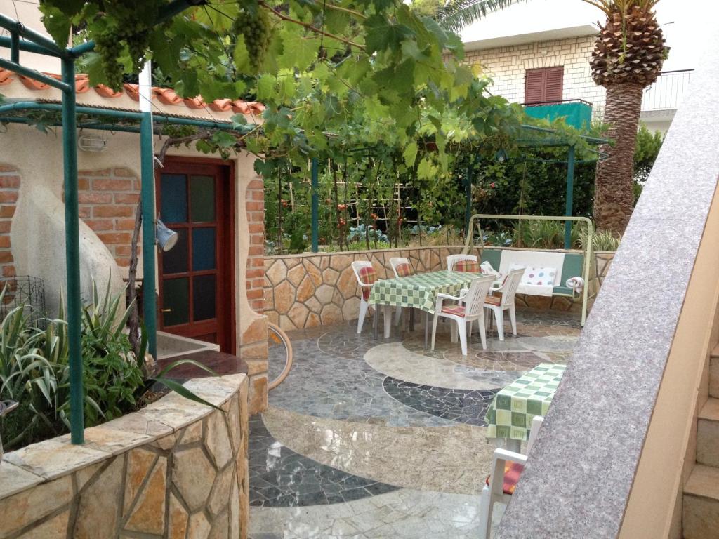 a patio with a table and chairs in a building at Apartment Burin Dvor in Rab