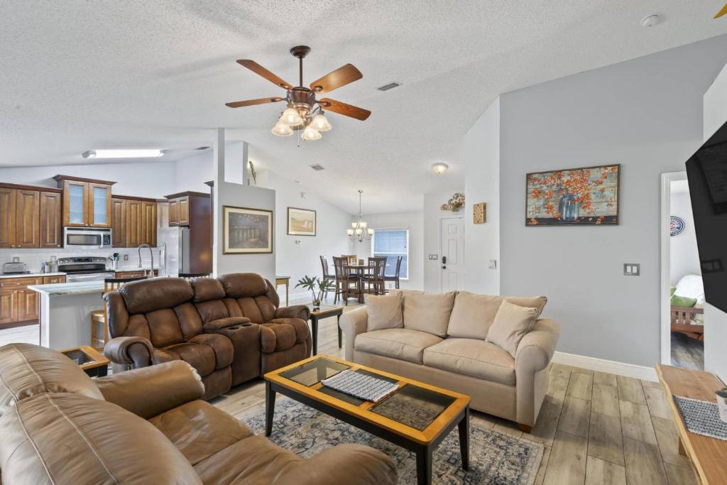 un soggiorno con divani e ventilatore a soffitto di Sandpiper Path | Palm Coast a Flagler Beach