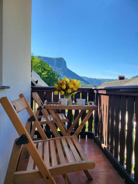 a wooden chair on a balcony with a vase of flowers at Bella Bela Apartments 18A in Bled