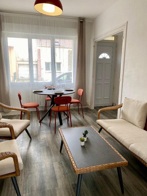 un salon avec un canapé, une table et des chaises dans l'établissement Les Passe-Pierres, à Merlimont