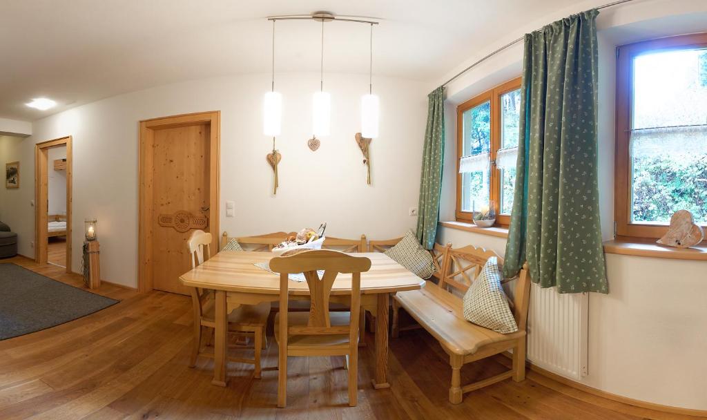 a dining room with a wooden table and chairs at S Mauthäusl Luftenstein in Sankt Martin bei Lofer