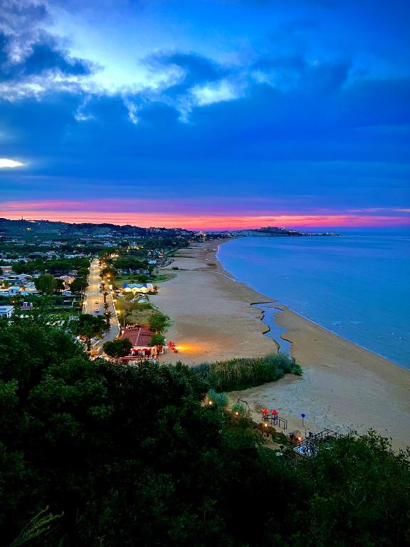 a view of a beach at sunset with the ocean at Villa Latino in Vieste