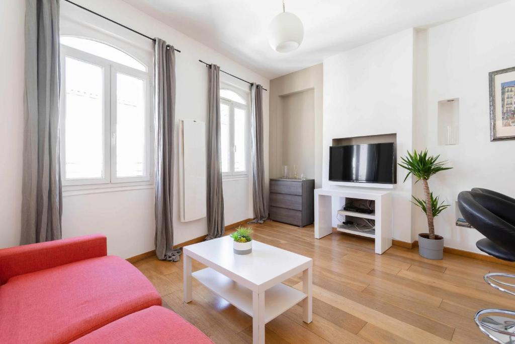 un salon avec un canapé rouge et une télévision dans l'établissement Apartment in the heart of the Old Port, à Marseille