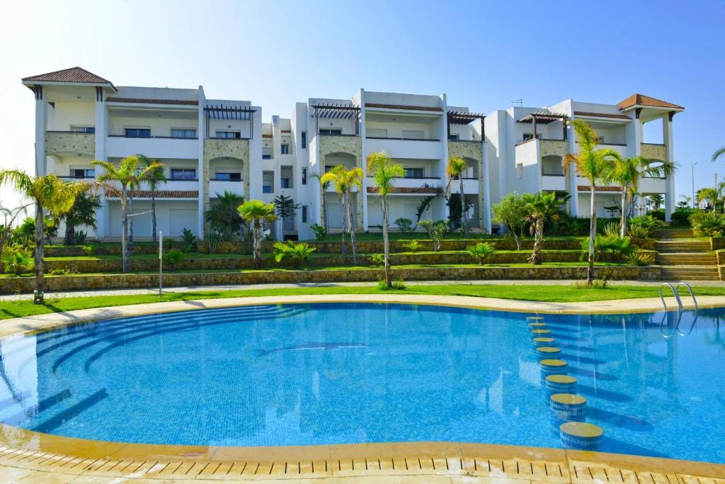 a swimming pool in front of a building at Appartement 1 chambre vue mer latérale - Marina Golf Asilah in Asilah