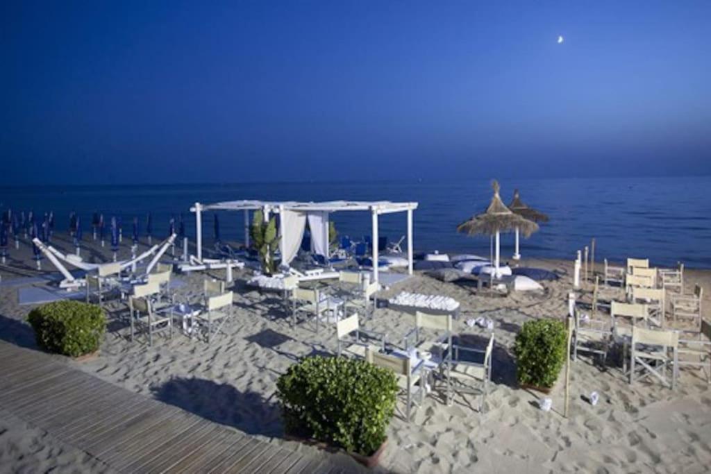 a beach with chairs and umbrellas and the ocean at Villetta vista mare Donna Lisa in Capilungo