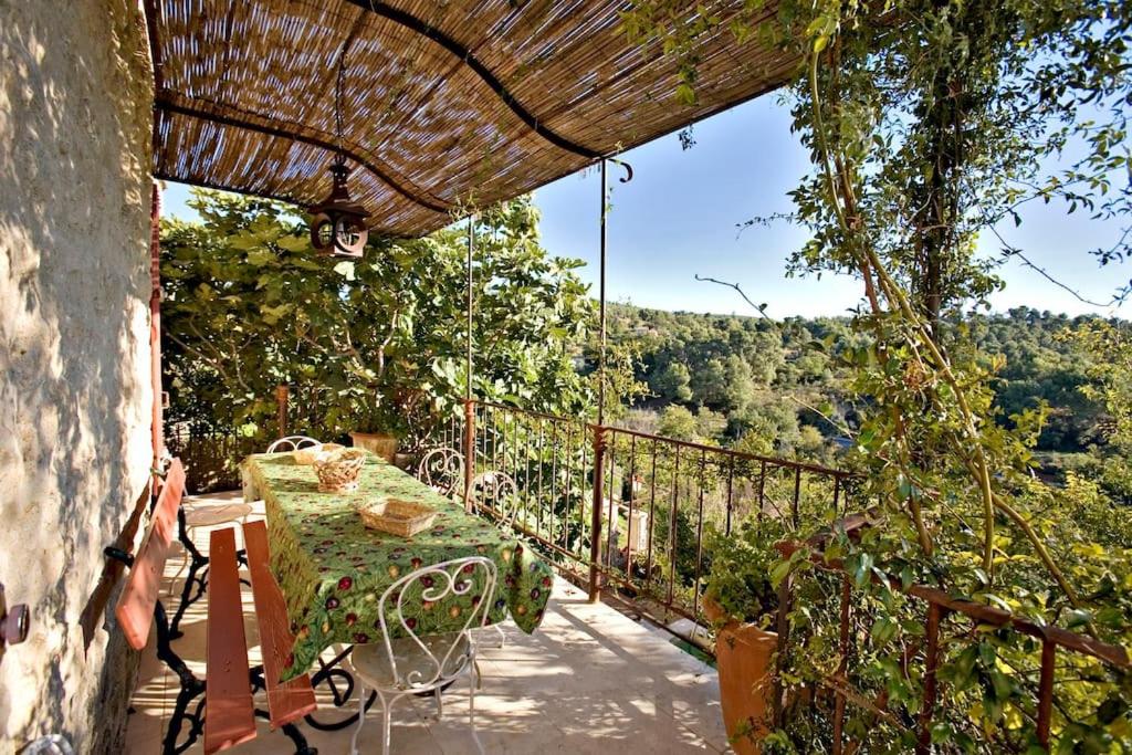 un patio avec une table et des chaises sur un balcon dans l'établissement La maison Renaissance, à Grambois