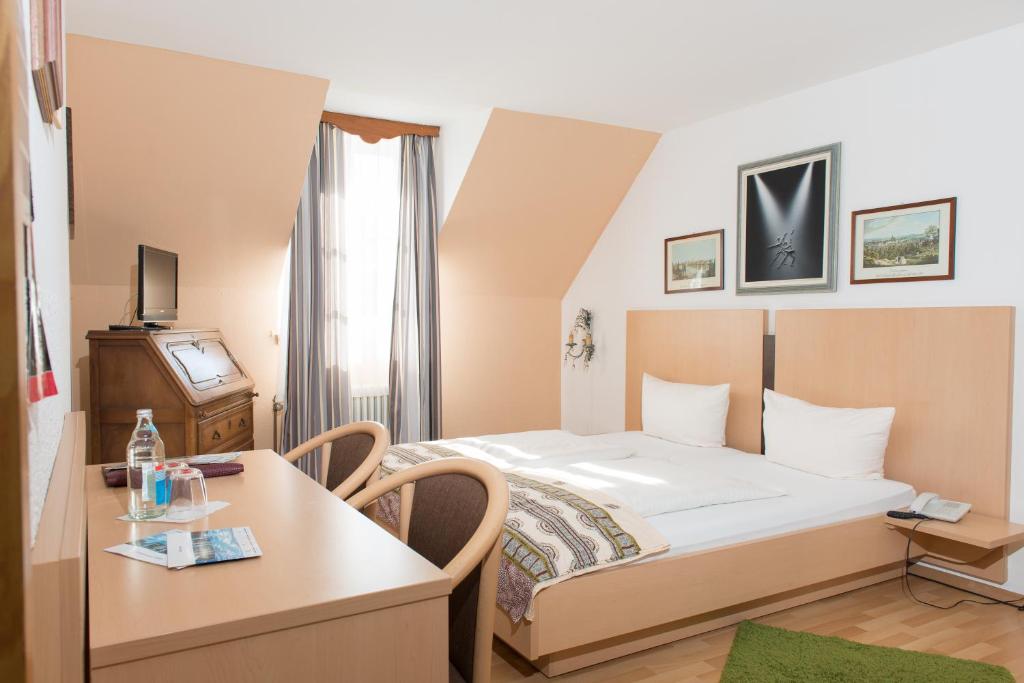 um quarto de hotel com uma cama e uma mesa em Hotel am Friedrichsbad em Baden-Baden