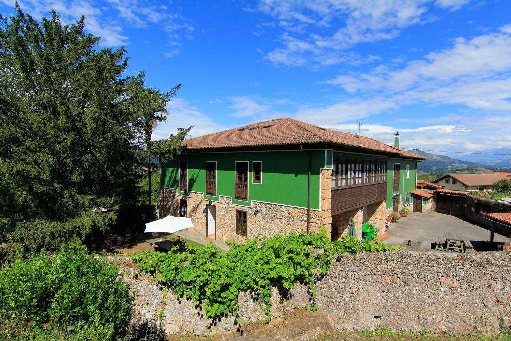 un edificio verde y marrón con un montón de vides en Hotel Rural Cuadroveña, en Arriondas