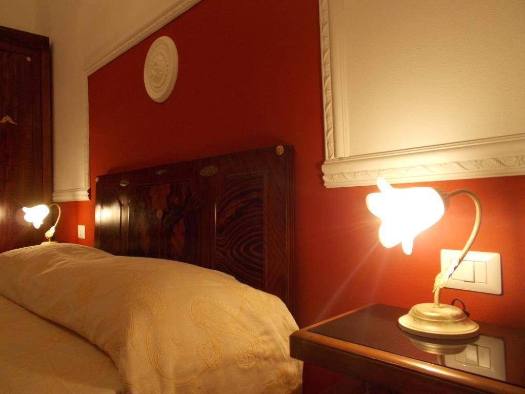 a bedroom with a bed and a table with a lamp at B&B Historia Magistra in SantʼAntìoco