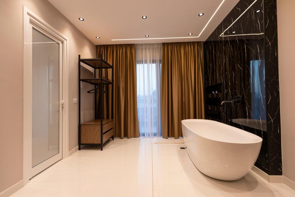 a bathroom with a large white bath tub in a room at Diol Hotel Ksamil in Ksamil