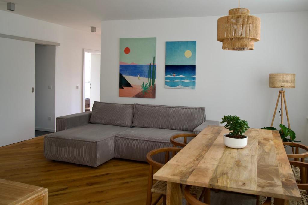 ein Wohnzimmer mit einer Couch und einem Tisch in der Unterkunft Urban Oasis in Klagenfurt am Wörthersee