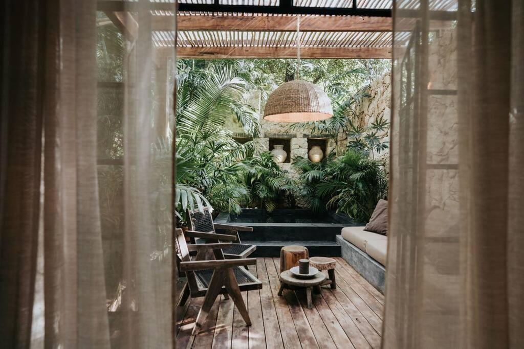 图卢姆Design Loft with private pool and SPA like feature的带沙发和一些植物的客厅