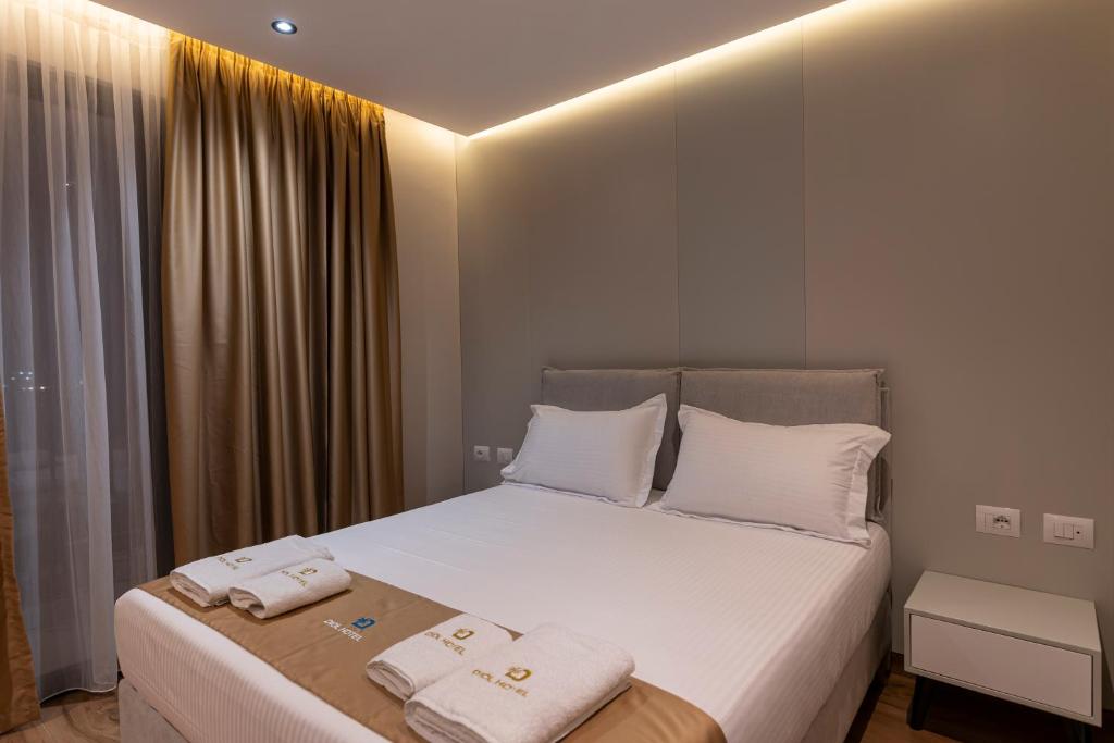 a bedroom with a bed with two towels on it at Diol Hotel Ksamil in Ksamil